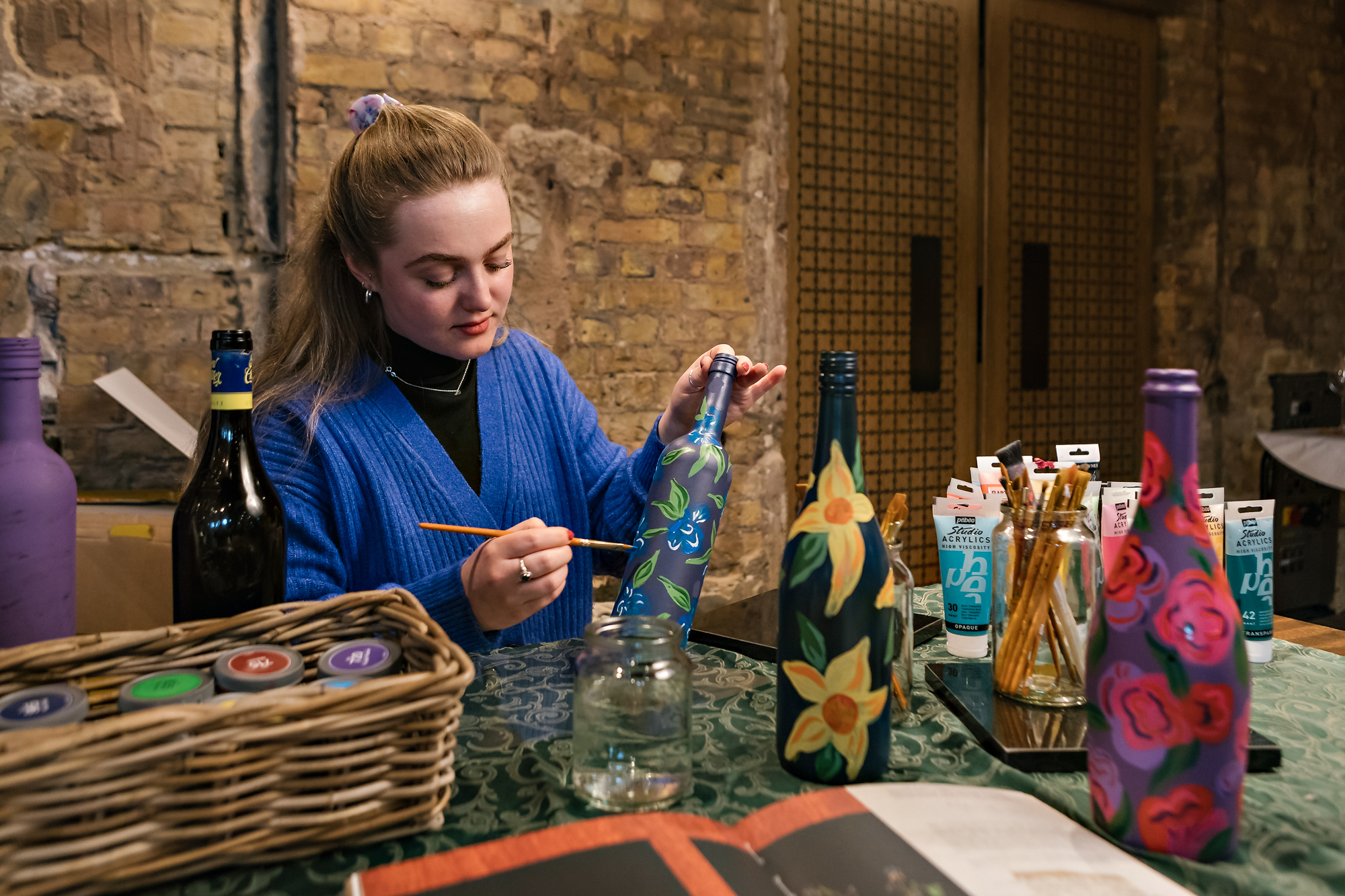 Hattie Hawes painting wine bottles 